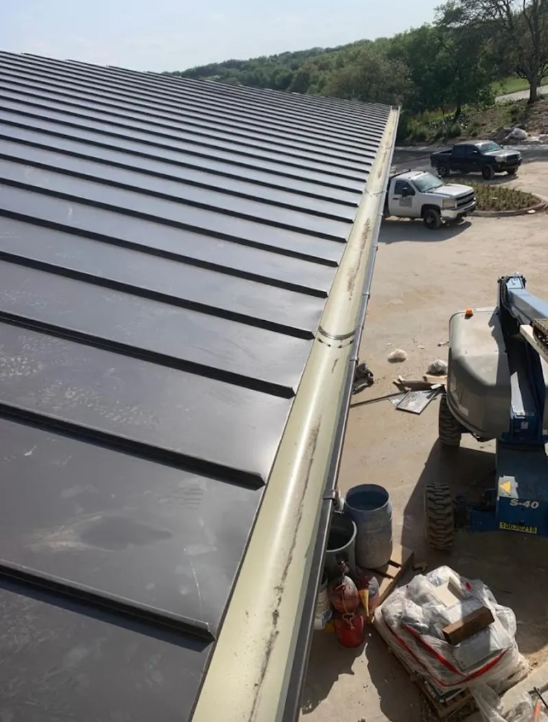 Standing seam panel and gutter detail on a metal roofing jobsite in Bristol
